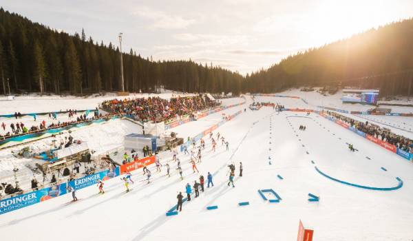 cross-country skiers gliding across the plateau with snow-covered forests in the background