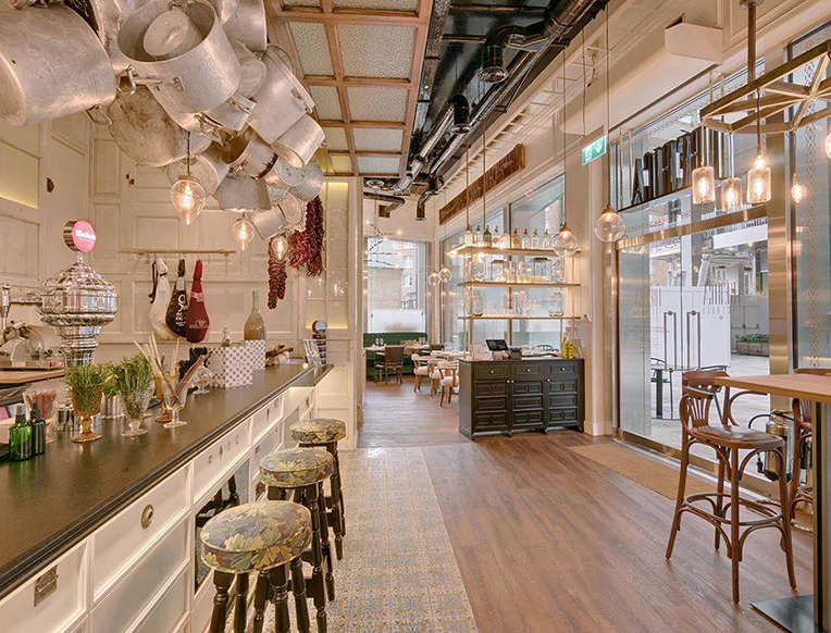 A glass of vermouth served with olives and Manchego cheese