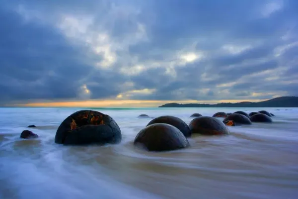 Moeraki Boulders on Koekohe Beach, New Zealand showcasing the smooth, rounded shapes of the boulders, some measuring over two meters in diameter, and the intricate cracks and patterns adorning their surfaces.
