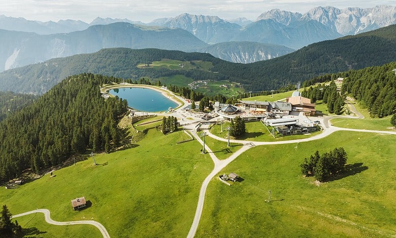 A bungee jumper in mid-air, with the Ötztal glaciers clearly visible in the background. Capture the intense expression of exhilaration on the jumper's face. The composition should use dynamic angles. The lighting could be brighter to accentuate the turquoise waters.