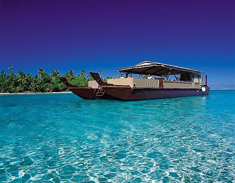Image of the stunning Aitutaki Lagoon, showcasing its turquoise waters and the various motu (islets) dotting the horizon, best captured from above, perhaps from a paragliding experience or a scenic flight.