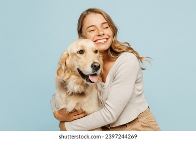 A young woman smiling and walking her dog.