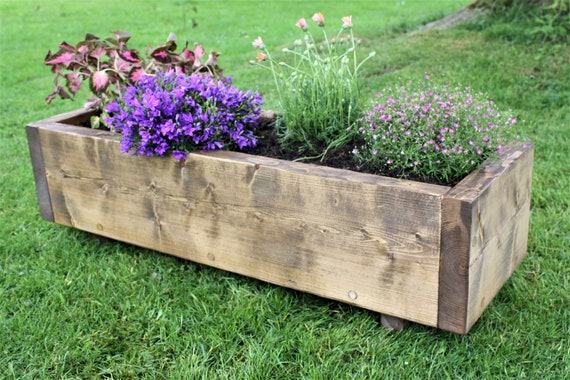 close-up, hands safely disassembling a wooden pallet with a saw, bright daylight, wooden texture visible, focus on the tool cutting through the wood.
