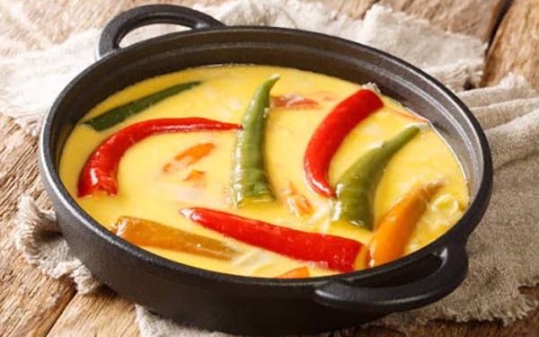 A close-up shot of Ema Datshi, Bhutan's national dish of chili peppers and cheese, highlighting the vibrant color and texture.