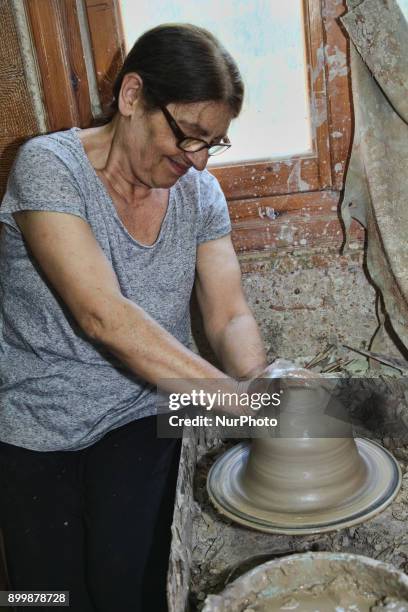 A photo of Anya participating in a pottery workshop, showcasing her interacting with local artisans. Capturing the hands-on nature of the activity and the smiles on their faces.