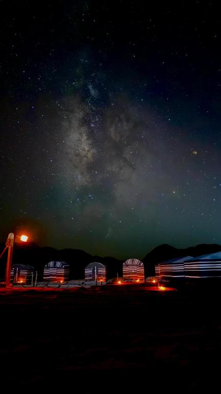 Wide angle shot of fairy circles stretching to the horizon, taken from a high vantage point. Use dramatic lighting from either sunrise or sunset to highlight the contrast between the barren earth and the circles