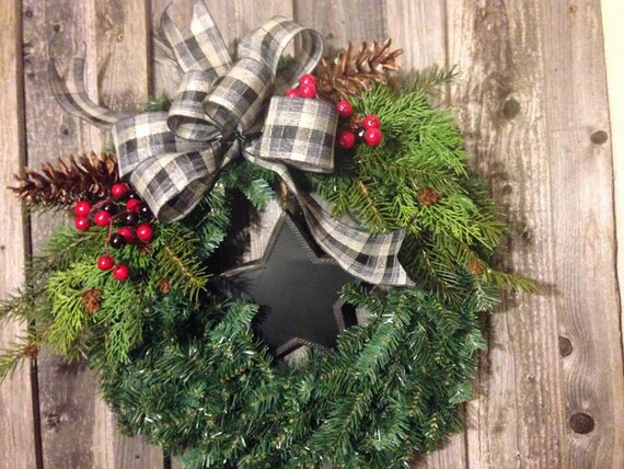 Close-up of attaching evergreen bundles to a grapevine wreath base using florist wire, demonstrating the technique for creating a lush foundation.