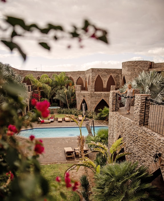 Close-up of hands rapidly weaving intricate patterns on a cane basket, highlighting the skill and artistry of the Papunya Tula artists.