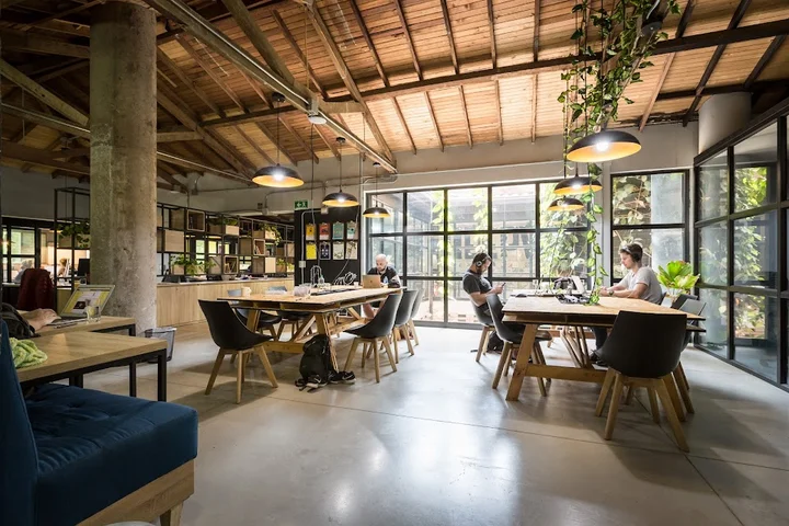 A vibrant photo of the Selina Medellin coworking space, showing people working on laptops in a colorful and modern environment. The alt text focuses on the collaborative atmosphere and amenities for digital nomads.