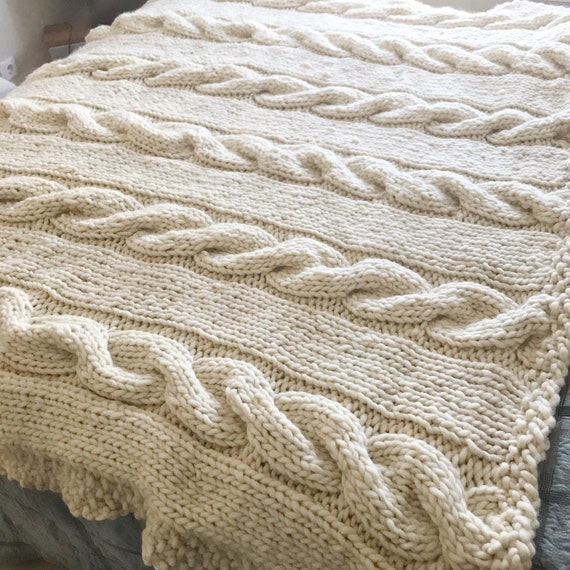 A close-up of a chunky knit wool throw, emphasizing its texture and warmth.