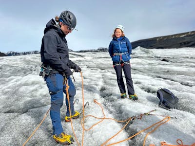 solo female traveler ice climbing a massive blue glacier in Iceland, showcasing strength and resilience