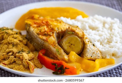 A steaming pot of Moqueca on a rustic wooden table at a beachfront restaurant in Paraty