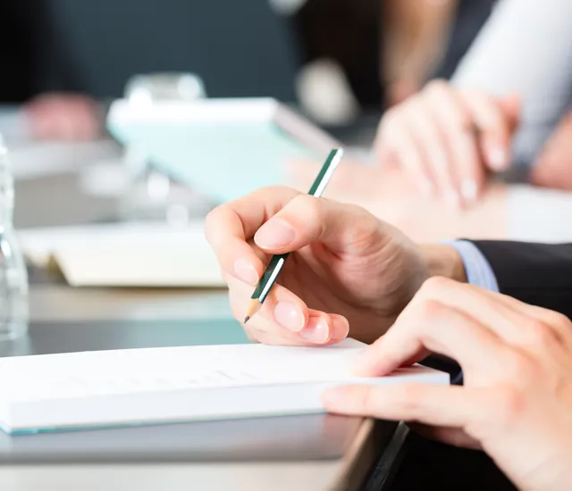 A screenshot of Deep Rock Galactic, showing four dwarven miners battling hordes of alien creatures in a dimly lit cave.