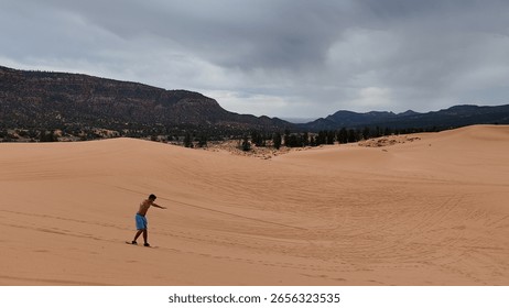 A sandboarder carves down a massive Atacama dune during golden hour, capturing the speed and intensity of the sport with a shallow depth of field.