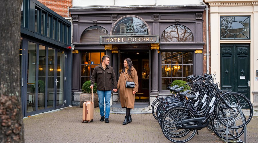 The exterior of The Pulitzer Amsterdam at dusk, lights reflecting off the canal.