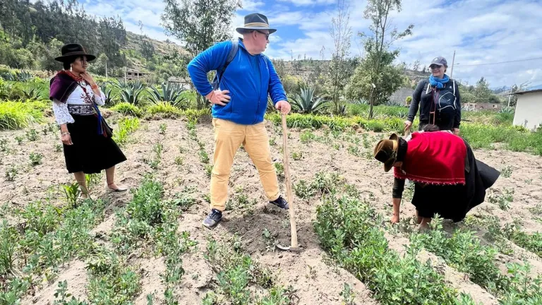 Indigenous women in Parque Nacional Cajas, Ecuador, wearing traditional clothing and engaged in a craft, representing the vibrant culture and sustainable practices of the local community.