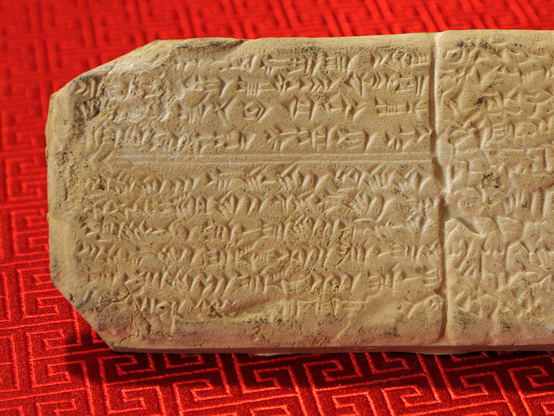 Dr. Aris Kaplanis, a Greek data scientist in his late 30s with short dark hair and a trimmed beard, staring intently at a monitor displaying complex data visualizations of the Phaistos Disc.