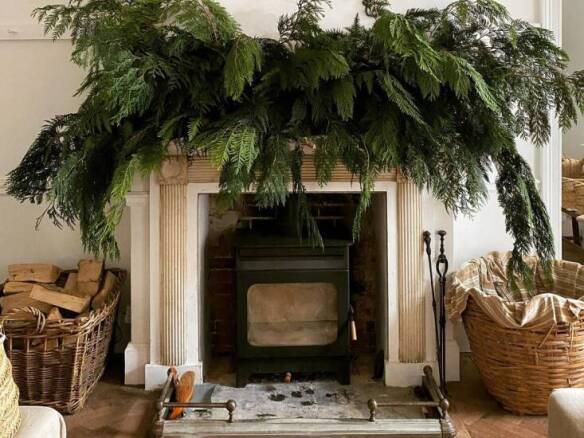 A mantel adorned with greenery and candles