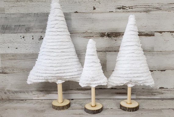 Handcrafted felted wool ball strings in white, gray, and deep red, draped artfully alongside paper snowflakes on a Scandinavian mantel.