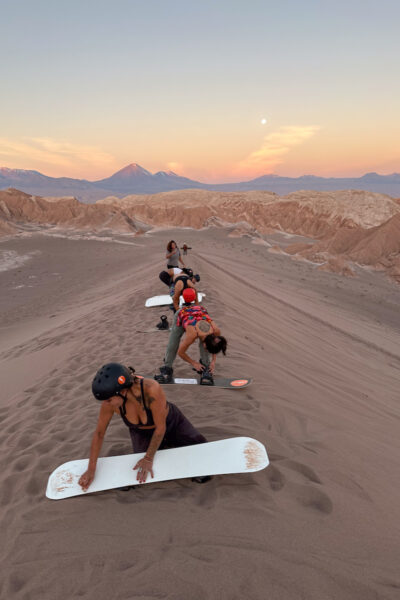 An action shot of someone sandboarding down a dune in Death Valley