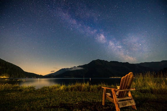 The Milky Way reflected on the surface of Lake Cushman, captured with a DSLR camera.