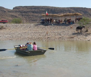 A colorful street scene in Boquillas del Carmen, Mexico, with the Rio Grande in the background. Alt text: A vibrant scene from Boquillas del Carmen, Mexico, showing the charm of the border town and the Rio Grande dividing the two countries, a popular day trip for Big Bend campers.