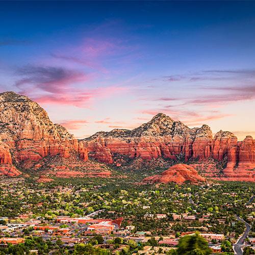 A view of Sedona from above, showing the red rocks and green trees.