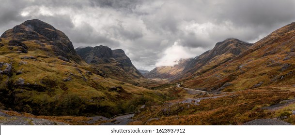 A panoramic view of the Scottish Highlands, with rolling hills and a cloudy sky