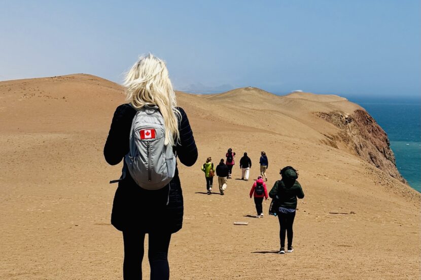 Sandboarding in Lancelin, Western Australia, a person standing on a white sand dune holding a sandboard