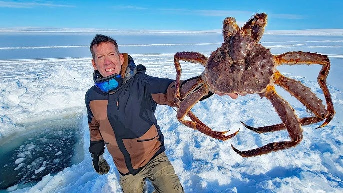 Local fishermen pulling up a King Crab through a hole in the ice, showcasing the unique Arctic environment and the excitement of the King Crab Safari.