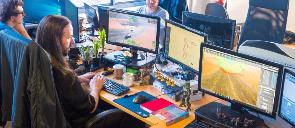 A group of game developers collaborating on a project, visually representing the potential positive impact of CD Projekt Red North America on the game development community.