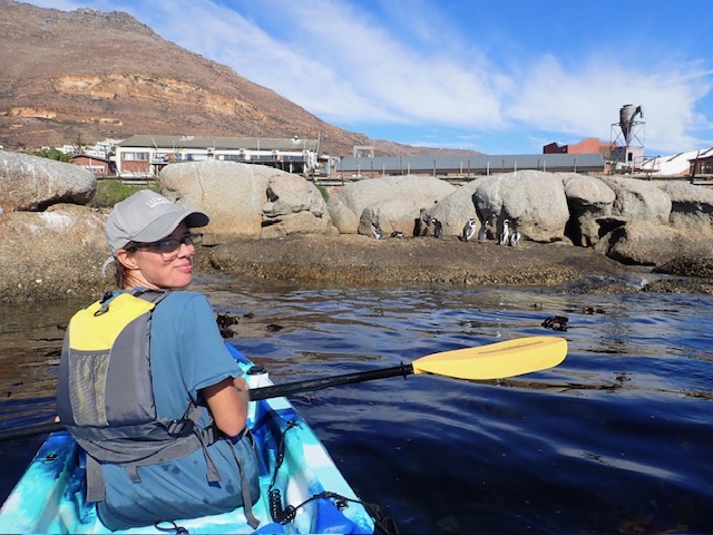 A family kayaking through a kelp forest, with a marine biologist pointing out sea otters and other marine life.