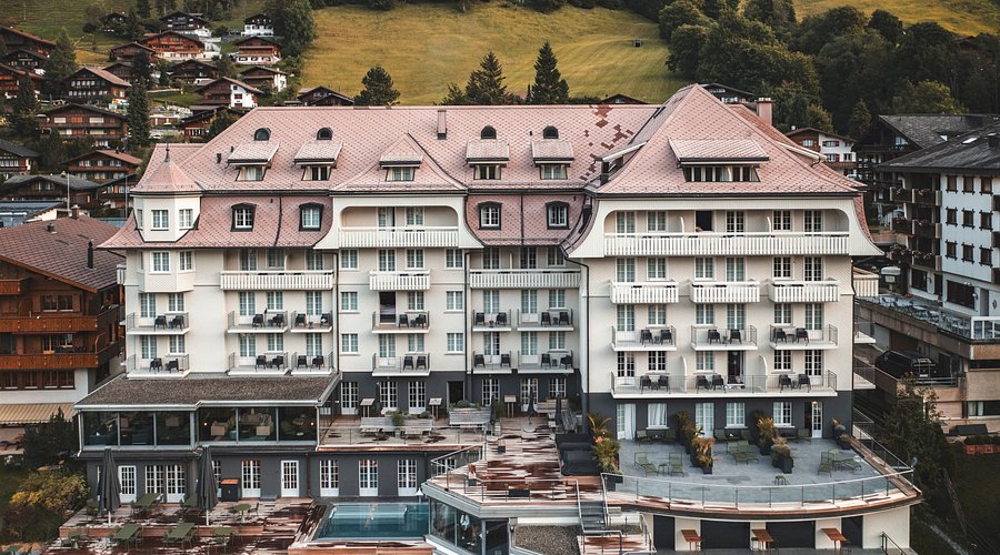 People sledding down a snowy hill, with a fondue pot in view