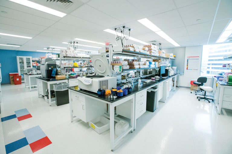A high-tech bioreactor with bubbling liquids and digital displays, representing the potential for creating complex biological systems.