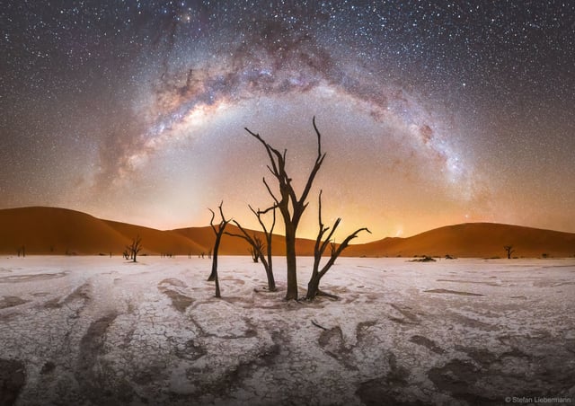 A night sky panorama in Damaraland, displaying the Milky Way's galactic center and constellations like Scorpius and Sagittarius.