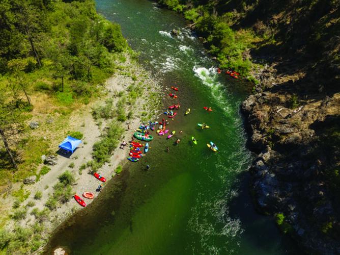 Snow Kayaking in Gudbrandsdalen Valley, Norway: A kayaker is mid-descent down a rapid on a snow-covered river, surrounded by snowy banks and pine trees. The perspective is a GoPro POV shot, capturing the thrill of the moment.