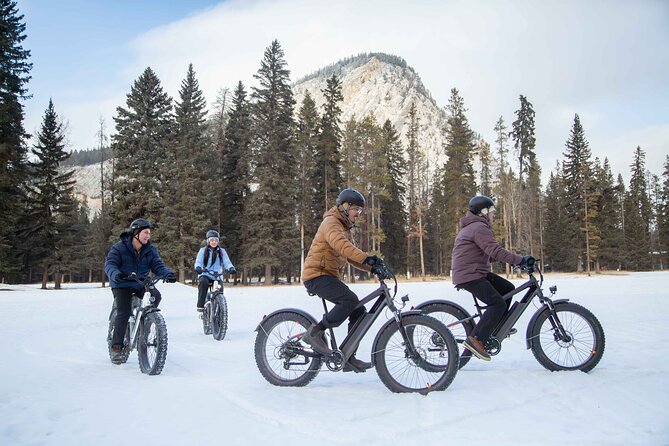fat bike riding on Lake Minnewanka with snow covered mountains in the background