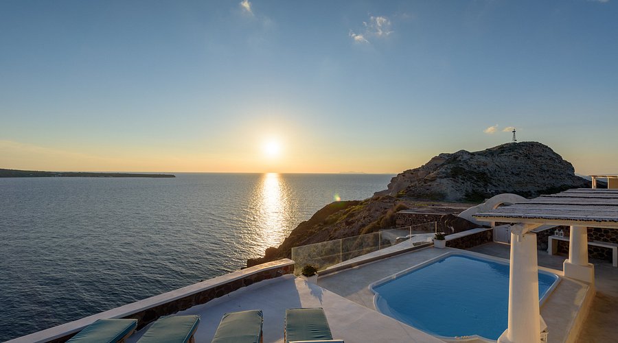 A luxurious suite with a private balcony overlooking the Aegean Sea in Santorini.