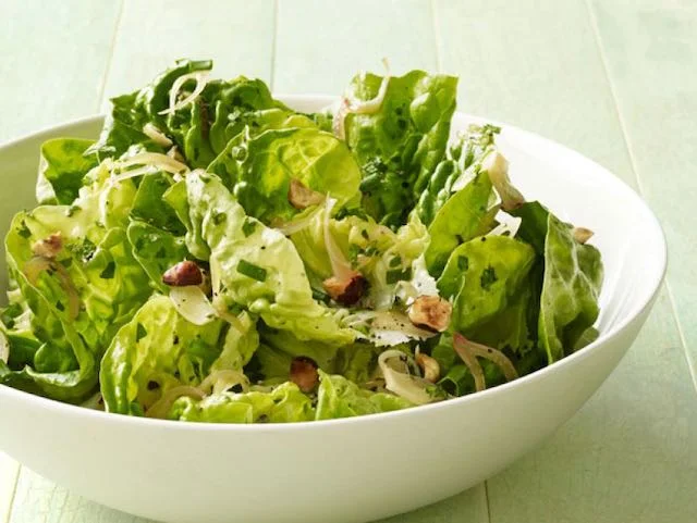 Mouthwatering photo of a finished salad with fresh greens, radishes, and herbs