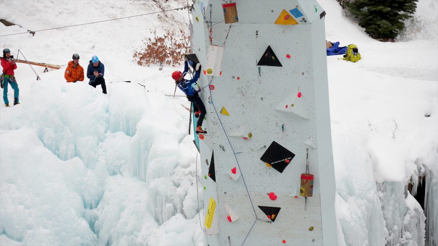 An ice climber ascends a frozen waterfall in Ouray, Colorado, highlighting the beauty and challenge of the sport.