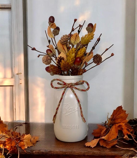 A handful of glossy acorns, carefully selected for their smooth caps, ready to be baked and incorporated into the fall centerpiece