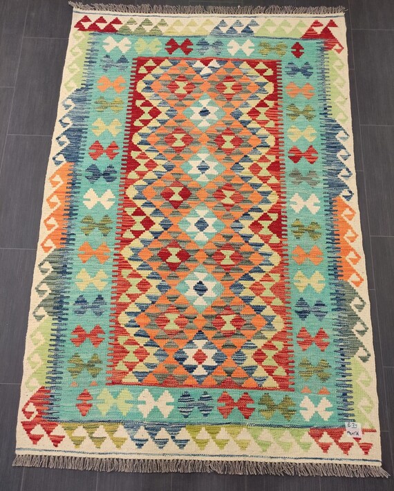 A view from a hot air balloon, looking down on Cappadocia's unique landscape at sunrise with other balloons in the distance.