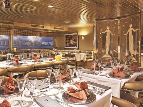 A luxurious cruise ship sailing on calm blue waters at sunset.