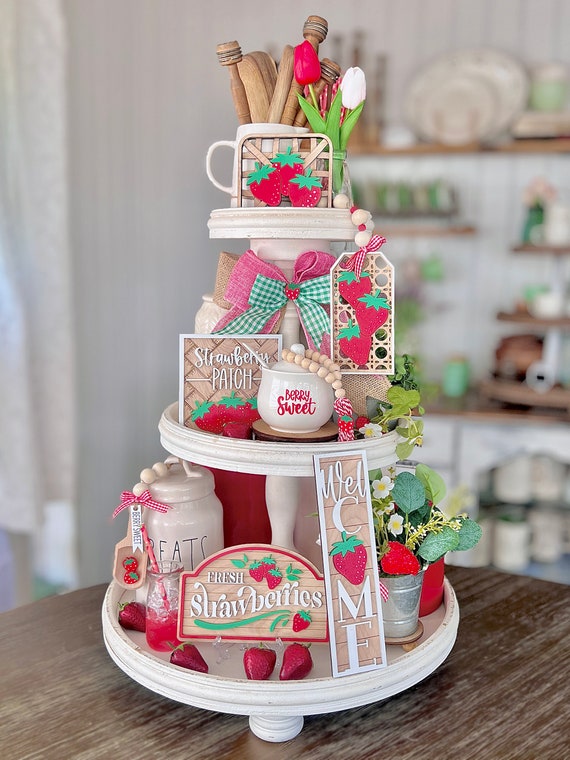 Close-up of a farmhouse kitchen hutch shelf with a white ceramic pie bird, surrounded by vintage cookbooks and kitchenware.
