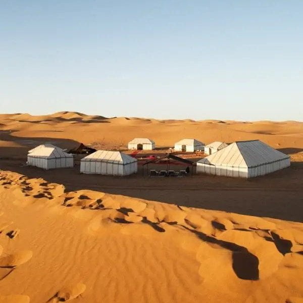 A vast landscape of the Sahara Desert with towering sand dunes, illustrating the windy conditions that produce the sounds of the desert.