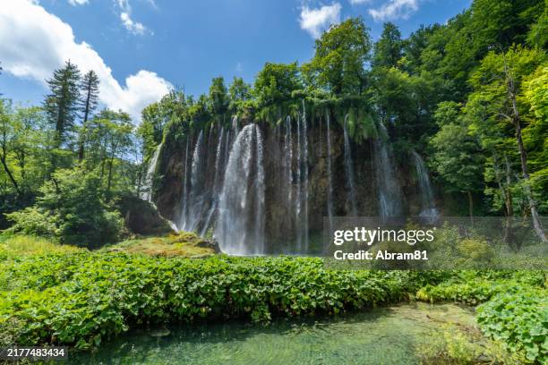 A view of the Plitvice Lakes waterfalls cascading over tufa barriers into the turquoise water below.