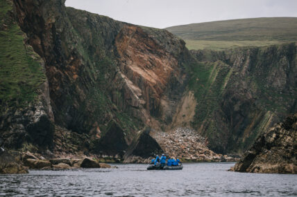 Zodiac boat tour approaching the cliffs of St. Kilda, Scotland