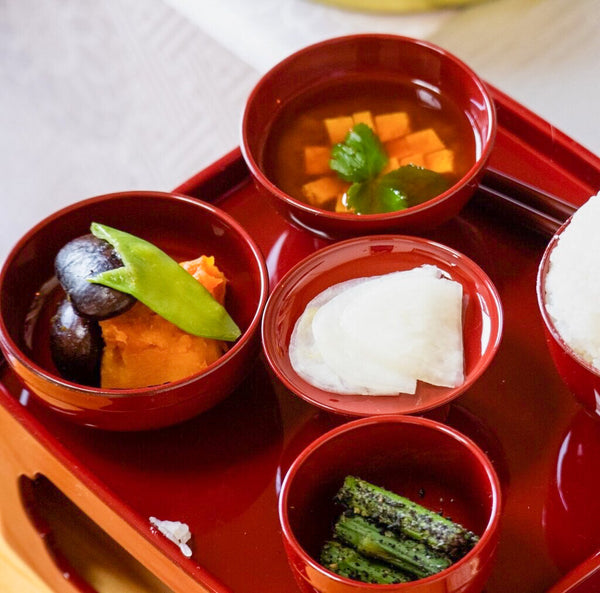 A beautifully arranged Shojin Ryori meal, featuring various small dishes with colorful and fresh ingredients. The image illustrates the artful presentation and variety of textures and flavors typical of this cuisine.