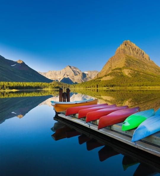 The Friends Kayaking on Swiftcurrent Lake, with the Mountains in the Background