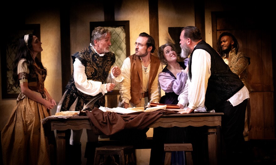 A bowl of ciorbă de burtă (tripe soup) on a wooden table, with a spoon and a small glass of țuică (plum brandy).